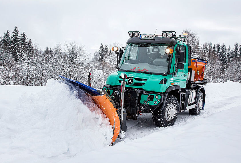 Im österreichischen Winterchaos räumt Unimog zugeschneite Gebäudedächer.