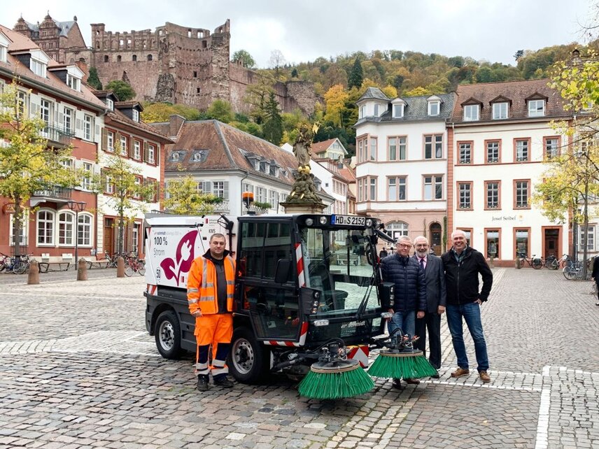 Die erste elektrische Kehrmaschine Heidelbergs ist in der Altstadt im Einsatz. Das Bild zeigt (v.l.n.r.): Oleg Valjavin, Fahrer der neuen Elektrokehrmaschine, Rolf Friedel, Leiter der Abfallwirtschaft und Stadtreinigung Heidelberg, Bürgermeister Wolfgang Erichson und Michael Kraft, Leiter des Regiebetriebs Reinigung.