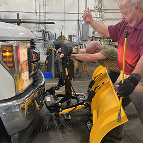 Marty Warchola y Lou Orazem trabajan con la ciudad de Medina en la instalación de un arado Wingman, poniendo la ingeniería en acción.