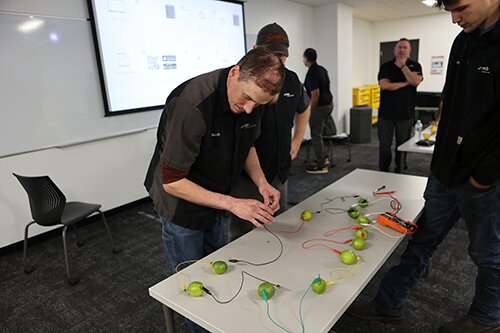 Deelnemers nemen deel aan diverse activiteiten om systeemkennis en vaardigheden voor noodsituaties onder de knie te krijgen.